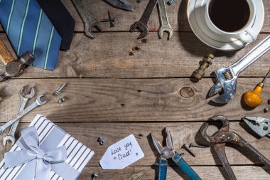Babalar Günü tebrik kartı geçmişi. Babalar günü konsepti hediye kutusu, aletler ve kravatlar, kahve fincanı, hediye etiketi, baban seni seviyor, kırsal ahşap arka planda fotokopi odası