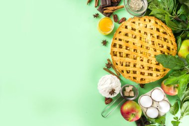  Sonbaharda elmalı turtayla pişirme arka planı. Geleneksel Amerikan elmalı turtası taze elmalar, tarçın, baharatlar, fırın malzemeleri, açık yeşil arka planda üst görünüm kopyalama alanı