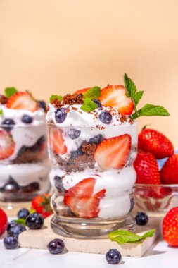 Çilekli tatlı, katmanlı parfe tatlı çikolatalı bisküvi, çırpılmış krema ve taze böğürtlen. Bardakta yaz kahvaltısı tatlısı