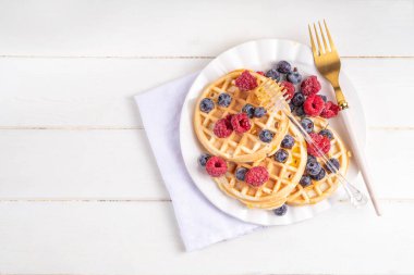 Beyaz ahşap masadaki böğürtlenli ev yapımı Belçika waffle 'ları lezzetli brunch' lar ya da Belçika waffle 'ları.