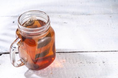 Mason kavanozunda güneş çayı, modaya uygun soğuk, tatlı güneş çayı ahşap masada içki.