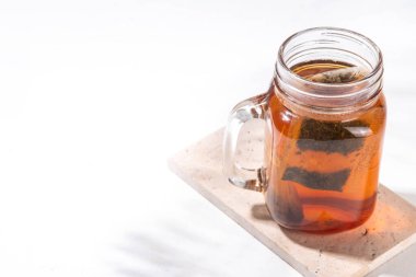 Mason kavanozunda güneş çayı, modaya uygun soğuk, tatlı güneş çayı ahşap masada içki.