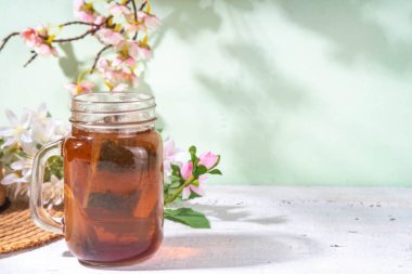 Mason kavanozunda güneş çayı, modaya uygun soğuk, tatlı güneş çayı ahşap masada içki.