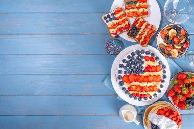 4 Temmuz, Vatansever Bağımsızlık Günü tatlıları. 4 Temmuz tatlı kahvaltı yemeği ve atıştırmalıklar - tost sandviçleri, böğürtlenli gevrek, kek, krep, bardaklı şampanya, bayram dekoru, bayraklar 