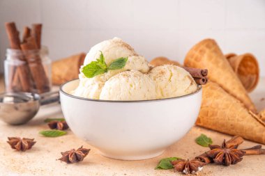 Hindistan 'da soğuk yaz Garam Masala Gelato tatlısı, Hindistan' da üç baharatlı dondurma, beyaz seramik kasede, nane yaprakları, baharatlar ve kremalı dondurma külahları.
