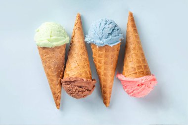  Parlak arka planda waffle külahlı renkli parlak dondurma. Taze böğürtlenli farklı dondurma külahları üst görünüm fotokopi alanı arka planı