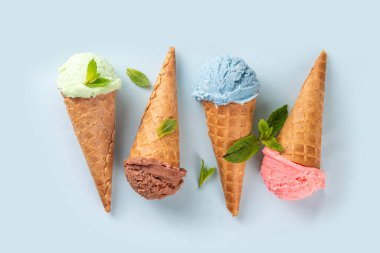  Parlak arka planda waffle külahlı renkli parlak dondurma. Taze böğürtlenli farklı dondurma külahları üst görünüm fotokopi alanı arka planı