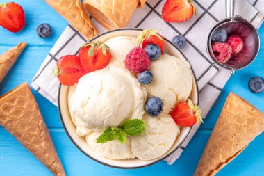 Vanilyalı dondurma kasesi ve taze böğürtlen. Klasik vanilyalı dondurma, çilek, ahududu, böğürtlen, böğürtlen ve kremalı dondurma.