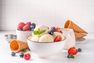 Vanilyalı dondurma kasesi ve taze böğürtlen. Klasik vanilyalı dondurma, çilek, ahududu, böğürtlen, böğürtlen ve kremalı dondurma.