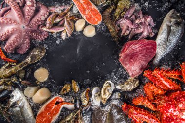 Çeşitli taze çiğ deniz ürünleri seti - ahtapot, yengeç, kalamar, karides, istiridye, midye, somon balığı limon baharatlı ton balığı, ezilmiş buzlu arka plan üst görünümü olan siyah arkaplan 