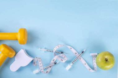 Kilo kaybı enjeksiyonu. İnsülin direnci, diyabet, sağlıklı beslenmeyi zayıflatmak. Hormon enjeksiyonları şırıngalar, mezuralar, dambıllar, dengeli tabak salatası, et ve elma.