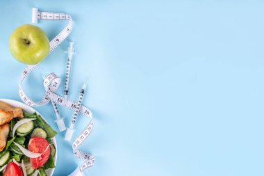 Kilo kaybı enjeksiyonu. İnsülin direnci, diyabet, sağlıklı beslenmeyi zayıflatmak. Hormon enjeksiyonları şırıngalar, mezuralar, dambıllar, dengeli tabak salatası, et ve elma.
