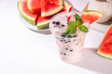 Watermelon boba balls bubble tea cocktail. Refreshing milky non-dairy milkshake cocktail with boba balls and watermelon slices on background. Summer garnished sweet dessert iced drink  clipart