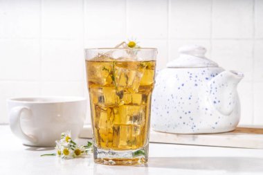 Bitki çiçeği papatya papatya buzlu çayı, papatya papatyası kır çiçeği ve buz küpleriyle doldurulmuş soğuk bir içecek, kopyalama alanı.