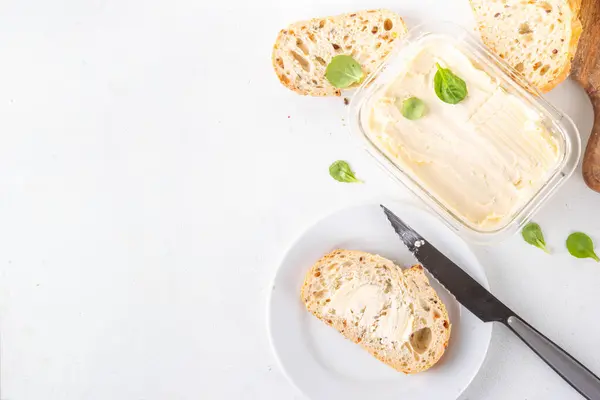 stock image Homemade Vegan Butter, non-dairy creamy, plant based alternative butter with soy bean leave, and home baked bread on kitchen white table background