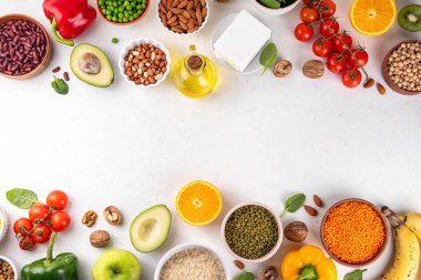 Portföy diyeti, fındık, sebze proteini, bitki sterolleri, yapışkan lif, fasulye, baklagiller, taze sebzeler ve beyaz arka plandaki meyveler dahil olmak üzere dengeli kolesterol vejetaryen gıdalar.