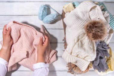 Sonbahar ve kış mevsimi için hazırlık, sonbahar sıcacık giysiler, temiz temiz temiz temiz çamaşır yığını, düzgünce katlanmış ceketler, kazaklar, şapkalar, ahşap kutudaki eldivenler, asma kattan alınan