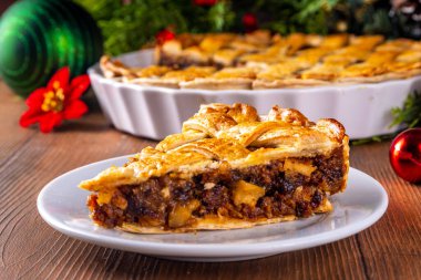 Geleneksel İngiliz Noel turtası. Ev yapımı tatlı kıymalı tart kek, baharatlı meyve, fındık ve elmalarla dolu, rahat ahşap masa üzerinde Noel ağacı ve süslemesi ile