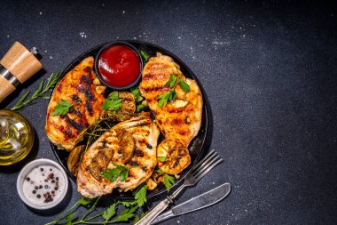 Kızarmış tavuk, hindi fileto. Baharatlı bbq kızarmış beyaz et, sarımsaklı, biberiyeli, limonlu, ketçap soslu, arka planda siyah beton masa arkaplanlı, kemiksiz fileto.