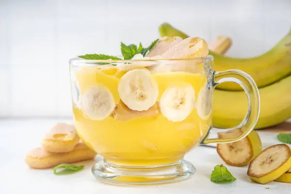 stock image Banana Pudding Dessert on Glass cup. Layered parfait dessert with cookies and banana slices, copy space