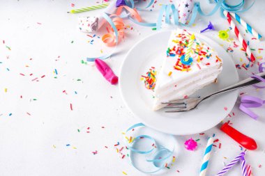 Doğum günü pastası dilimi, parti dekore masasında. Doğum günü pastası beyaz kremalı, şeker serpintili funfetti ve mum, kopyalama alanı