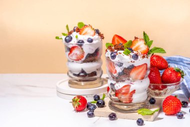 Çilekli tatlı, katmanlı parfe tatlı çikolatalı bisküvi, çırpılmış krema ve taze böğürtlen. Bardakta yaz kahvaltısı tatlısı