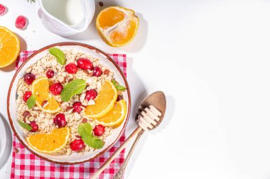 Noel sabahı kahvaltı tarifi, kızılcık portakalı yulaf ezmesi. Beyaz masa manzaralı, meyveli ve meyveli yulaf lapası.