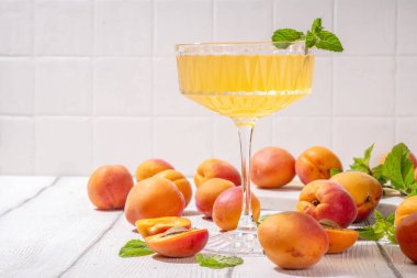 Kayısı martini ya da margarita ya da limonata soğuk meyve suyu, nane ve limonlu yaz meyve suyu kokteyli, beyaz ahşap masa.