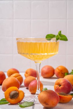Kayısı martini ya da margarita ya da limonata soğuk meyve suyu, nane ve limonlu yaz meyve suyu kokteyli, beyaz ahşap masa.