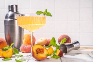 Şeftalili martini ya da margarita ya da limonata soğuk meyve suyu, nane ve limonlu yaz meyve suyu kokteyli, beyaz ahşap masa.