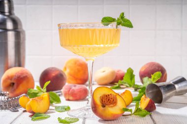 Şeftalili martini ya da margarita ya da limonata soğuk meyve suyu, nane ve limonlu yaz meyve suyu kokteyli, beyaz ahşap masa.