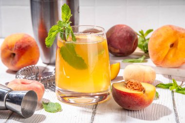 Şeftalili mojito ya da limonatalı soğuk meyve suyu, yaz buzlu meyve suyu nane ve limonlu moktail, beyaz ahşap masa.