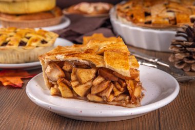 Geleneksel sonbahar elmalı turtası. Tatlı Şükran Günü yemeği, elmalı, tarçınlı, fındıklı ve karamel, vanilyalı dondurma kepçeli, ahşap arka planda