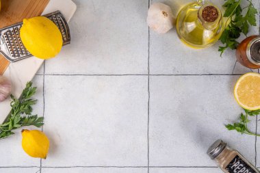 Yemek pişirmek, yemek hazırlamak, öğle yemeği hazırlamak, bembeyaz masa, taze malzemeler, baharatlar, baharatlar - limon, maydanoz, sarımsak, zeytinyağı, tuz ve biber, kopya alanı
