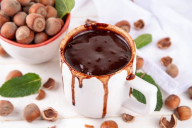 Beyaz fındıklı fındıklı sıcak çikolata, beyaz ahşap arka planda fındıklı, kopyalama alanı