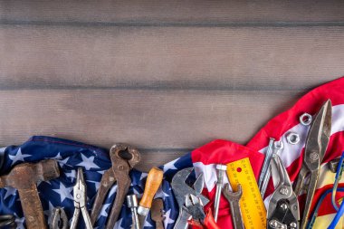 Amerikan Ulusal Vatansever İşçiler Mutlu İşçi Bayramı tatili geçmişi. Ahşap zemin üzerinde yıldızlı inşaat ve imalat araçları, kırmızı beyaz mavi çizgili Amerikan bayrağı
