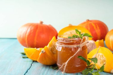 Altın kabak reçeli. Tatlı balkabağı ve portakal reçeli ya da küçük kavanozda dilimlenmiş balkabağı ve nane ile ahşap mutfak masasında bulunan konfeksiyon.