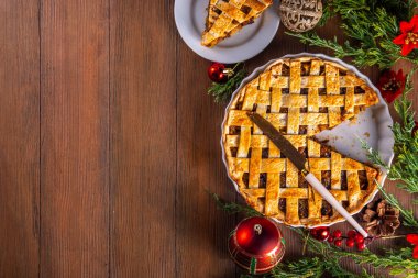 Geleneksel İngiliz Noel turtası. Ev yapımı tatlı kıymalı tart kek, baharatlı meyve, fındık ve elmalarla dolu, rahat ahşap masa üzerinde Noel ağacı ve süslemesi ile