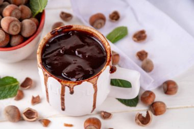 Beyaz fındıklı fındıklı sıcak çikolata, beyaz ahşap arka planda fındıklı, kopyalama alanı