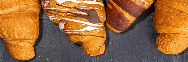 Taze pişmiş kruvasan ve kahve fincanı. Arka planda siyah fayanslı. Üst görünüm kopyalama alanı.