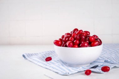 Cornelian kirazı, dogwoods yenilebilir dut mutfak masasının üzerinde beyaz kase içinde fotokopi alanı