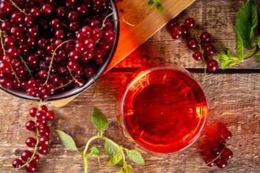 Kırmızı frenk üzümü suyu veya cam içinde likör, ahşap masa arkasında, naneli ve taze üzümlü üzümlü fotokopi alanı
