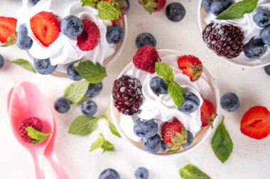 Çeşit çeşit çilek soslu donmuş yoğurt tatlısı. Ahududu, çilek, yaban mersini ve naneli kremalı yoğurtlu dondurma.