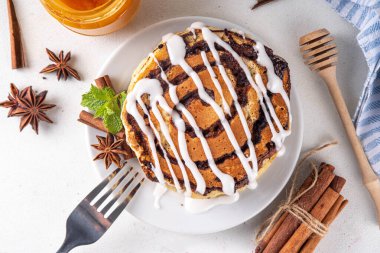 Ev yapımı tarçınlı krep yığını, tarçınlı krep sarmalı tarçın ve krem peynirli jöle, beyaz mutfak masası, fotokopi masası.