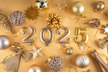Mutlu Noeller ve mutlu yıllar 2025 altın takı, noel ağacı topları ve süslemeleri, hediye yayı, yılan, 2025 altın mum numarası, düz görünüm fotokopi alanı