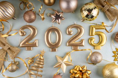 Mutlu Noeller ve mutlu yıllar 2025 altın takı, noel ağacı topları ve süslemeleri, hediye yayı, yılan, 2025 altın mum numarası, düz görünüm fotokopi alanı