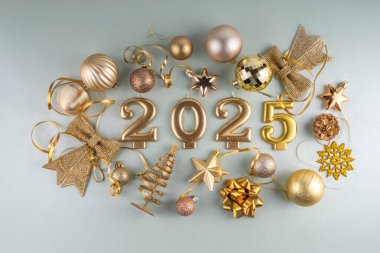 Mutlu Noeller ve mutlu yıllar 2025 altın takı, noel ağacı topları ve süslemeleri, hediye yayı, yılan, 2025 altın mum numarası, düz görünüm fotokopi alanı