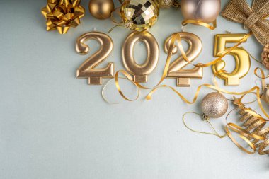 Mutlu Noeller ve mutlu yıllar 2025 altın takı, noel ağacı topları ve süslemeleri, hediye yayı, yılan, 2025 altın mum numarası, düz görünüm fotokopi alanı