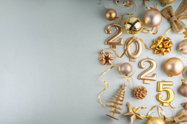 Mutlu Noeller ve mutlu yıllar 2025 altın takı, noel ağacı topları ve süslemeleri, hediye yayı, yılan, 2025 altın mum numarası, düz görünüm fotokopi alanı