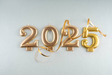Mutlu Noeller ve mutlu yıllar 2025 altın takı, noel ağacı topları ve süslemeleri, hediye yayı, yılan, 2025 altın mum numarası, düz görünüm fotokopi alanı